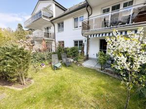 a yard with two chairs in front of a house at Ferienwohnung Strandläufer Whg 03 mit Terrasse in Thiessow