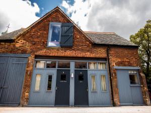 an old brick building with a blue door and windows at d'Parys in Bedford