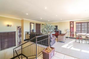 a living room with a staircase and a table at North Hill Guesthouse in Bloemfontein