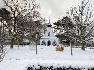 Eine weiße Kirche mit einem Kirchturm im Schnee in der Unterkunft Villa Salus Whg 5 Auszeit - mit 2 Bädern und Balkon in Baabe