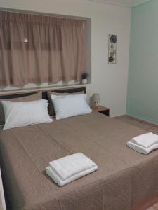 a bed with two white towels on top of it at Olivia Luxury Apartment in Mytilini