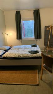een slaapkamer met een bed met een raam en een stoel bij Boafall Lodge in Jämshög