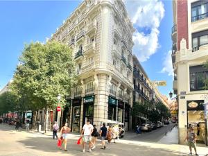 Leute laufen eine Straße vor einem Gebäude entlang in der Unterkunft Luz Madrid Rooms in Madrid