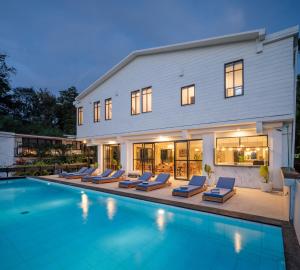 Ama Wela Living Labuan Bajo في Mbura: منزل مع مسبح وكراسي صالة