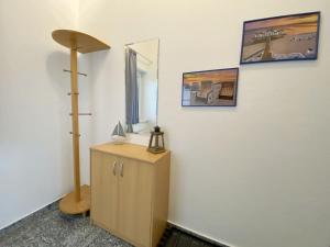 a room with a mirror and a dresser with a lamp at Residenz Binz - FeWo 16 in Binz +16 photos