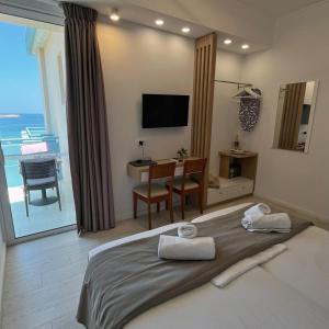 una camera da letto con un letto, una scrivania e una televisione di Christina Beach Hotel a Chania