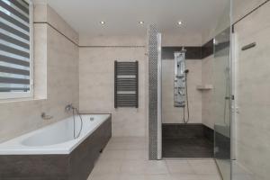 un bagno con vasca e doccia di Bystra Unique House in the Mountains with Terrace, Garden & Parking by Noclegi Renters a Bystra