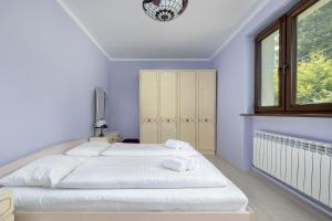 una camera da letto con un grande letto bianco con una finestra di Bystra Unique House in the Mountains with Terrace, Garden & Parking by Noclegi Renters a Bystra