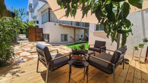 a patio with chairs and a table and a building at Ono Villa at Kiryat Ono in Qiryat Ono
