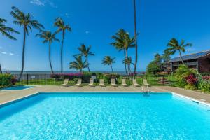 考纳卡凯Castle at Moloka'i Shores的有棕榈树和大海的游泳池