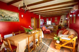 a dining room with red walls and a table and chairs at Casa Rural Cortijos San Jose in Iznájar