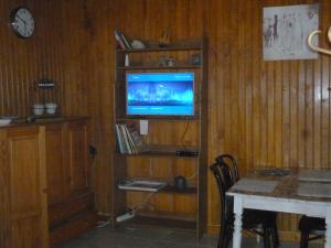 a living room with a tv on a wooden wall at Au coeur des vignes in Boudes