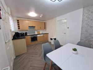 a kitchen with a table and chairs in a room at Spacious 4Bedroom Home Sleeps 7 with 2 Full Baths in Gateshead +16 photos