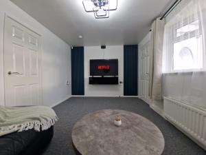 a living room with a table and a tv at Spacious 4Bedroom Home Sleeps 7 with 2 Full Baths in Gateshead