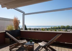 Dos sillas y una mesa en un balcón con vista. en Apartment Lichterfunkeln, en Daisendorf
