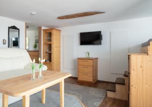 Habitación con cama, mesa y TV. en Apartment Lichterfunkeln, en Daisendorf