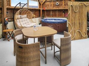 un patio con mesa, sillas y bañera en Alscott Annexe, en Bishops Tawton