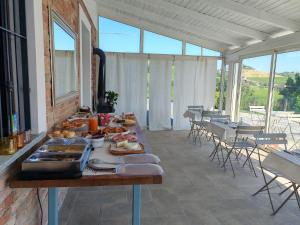 Una mesa con comida en una habitación con ventanas. en B&b La Creusa, en Calosso