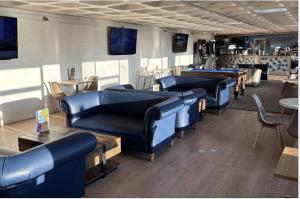 a waiting room with blue couches and tables and chairs at Woodland View Exec Van - Hot Tub - Private Parking - Hoburne Devon Bay in Paignton
