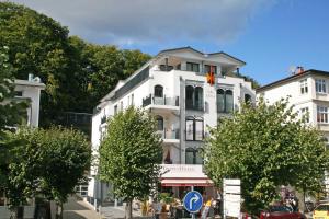 Villa Lena - Whg 09 mit Balkon في اوستيباد سيلين: مبنى أبيض عليه علم