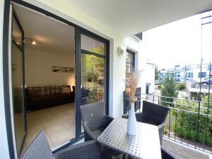 Villa Lena - Whg 09 mit Balkon في اوستيباد سيلين: شرفة مع طاولة وكراسي على شرفة