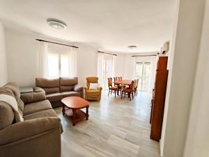 Una sala de estar con un sofá, una mesa y sillas. en Primera Linea Costa Ballena con Vista al Mar, en Costa Ballena