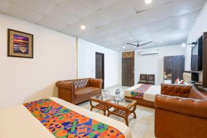 a room with two beds and a couch and a table at Via Lazeeno in Faridabad