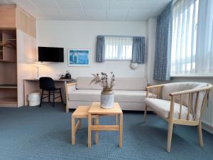 a living room with a couch and a table at Hotel Frederikshavn in Frederikshavn