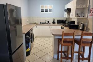 a kitchen with a refrigerator and a table and chairs at Triton Heights 7 in Linkside