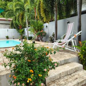 a pair of chairs and flowers next to a swimming pool at Your beautiful moments -Room 1-Ao Nang in Ban Chong Phli