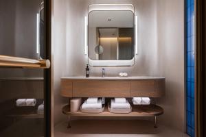 a bathroom with a sink and a mirror at Orange Crystal Qingdao May Fourth Square Olympic Sailing Center Hotel in Qingdao +16 photos