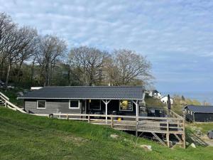 a small house on a hill next to a field at Cottage With A View- 5 Min From Beach in Allinge