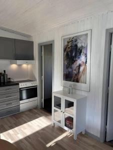 a kitchen with a white table and a painting on the wall at Cottage With A View- 5 Min From Beach in Allinge +11 photos