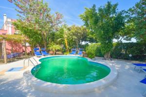 una piscina con sedie e alberi in un cortile di Albergo Italia - Beach Hotel a Ischia