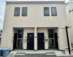 a building with two blue doors and two trash cans at Style Room in Osaka