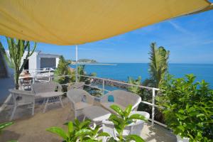 Un balcón con sillas, una mesa y el océano en Albergo Italia - Beach Hotel, en Isquia
