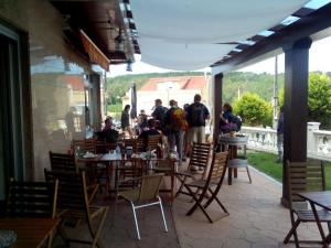 a group of people standing in a restaurant with tables and chairs at Albergue As Eiras in Lires