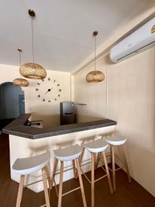 een keuken met een bar met een klok aan de muur bij Oh Town Villa in Thongsala