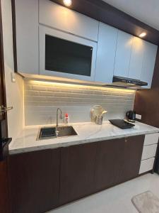 巴淡岛中心53rd Floor, 2 BR, Netflix, Apt with view by SKY的配有水槽和微波炉的厨房