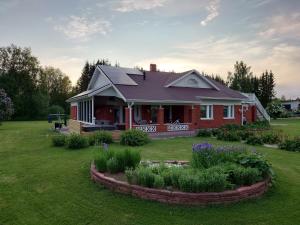 a red house with a garden in the yard at Arctic River Apartment in Rovaniemi