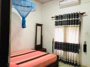a bedroom with a bed and a blue umbrella at Kandyan Rest in Talakolawela +64 photos