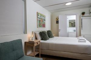 a bedroom with a bed and a blue chair at Ono Villa at Kiryat Ono in Qiryat Ono