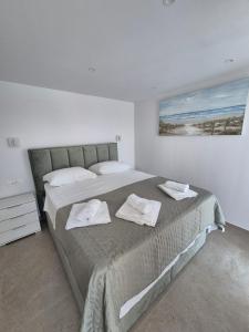 a bedroom with a large bed with two towels on it at Villa Rosea in Slatine +11 photos