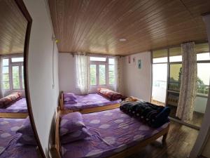 a bedroom with three beds and a mirror at Tinchuley Hillcrest Residence in Takdāh