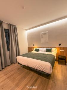 ein Schlafzimmer mit einem großen Bett vor einem Fenster in der Unterkunft Hotel Síbel Baza in Baza