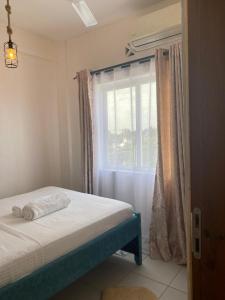 una camera da letto con un letto e una finestra di Ample home a Mombasa Altre 16 foto