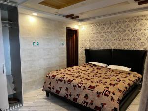 a bedroom with a bed with a quilt on it at Cozy 2 Bedrooms Cottage Apartment Changla Gali in Chhāngla Gali