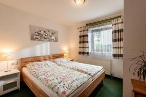 ein Schlafzimmer mit einem Bett und einem Fenster in der Unterkunft Haus Auebach in Ellmau