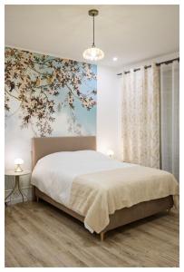 1 dormitorio con 1 cama grande y un mural floral en la pared en Joli studio face au Pavillon Baltard, en Nogent-sur-Marne