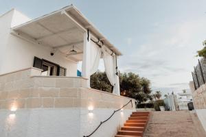 a white house with stairs and awning at Tufara Villa a Mare in Polignano a Mare